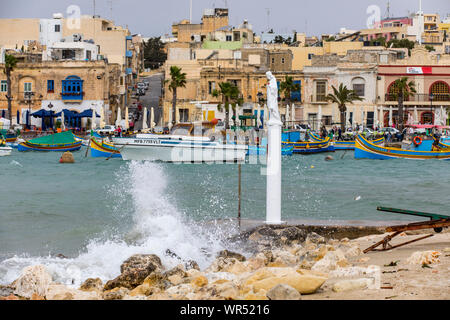 Le village de pêcheurs de Marsaxlokk, dans le sud-est de Malte, de nombreux bateaux de pêche traditionnels, Peter statue, saint des pêcheurs, Banque D'Images