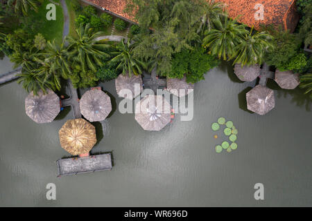 Vue aérienne d'un groupe de bâtiments en bois hexagonale traditionnelle Asiatique sur un étang réunis par des chemins élevés au-dessus de l'eau Banque D'Images