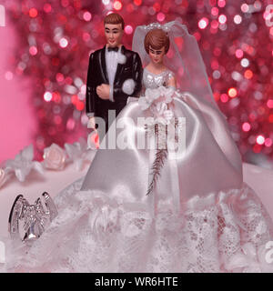 Close up of figurine miniature figures de gens comme couple mariée mariage et mariages robe bouquet & Groom horseshoe comme décoration de gâteau de mariage topper Banque D'Images