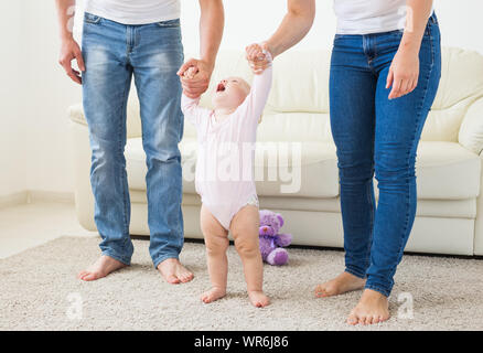 La famille, les enfants et la parentalité concept - enseignement parents baby girl de marcher. Banque D'Images