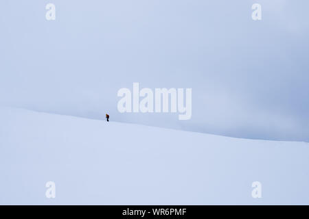 Personne non identifiable à marcher vers le sommet de montagne Storsteinen et le pic dans la neige parmi les merveilleux paysages d'hiver, la Norvège Banque D'Images