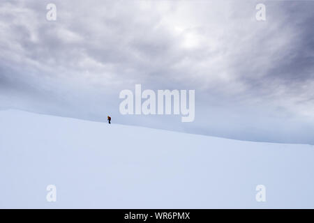 Personne non identifiable à marcher vers le sommet de montagne Storsteinen et le pic dans la neige parmi les merveilleux paysages d'hiver, la Norvège Banque D'Images