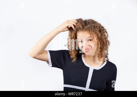 Jeune fille confus se gratter la tête à frustrés à fond blanc. Les droits de l'expression du visage, symbole signe le langage du corps. Banque D'Images