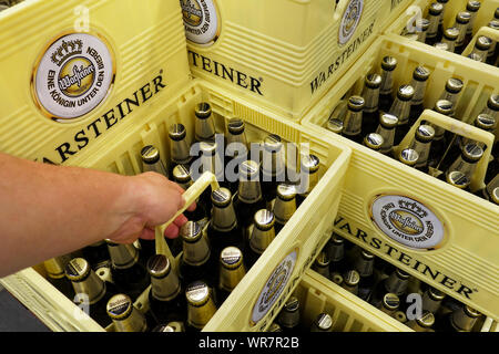 Part prend une caisse de bière Warsteiner dans un magasin Banque D'Images