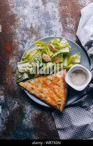 Romano salade avec des croûtons et de l'huile d'olive, quatre fromages pizza sur une base de béton. Vue d'en haut. Shot verticale Banque D'Images