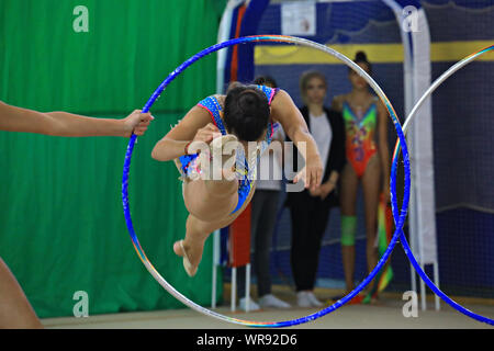 Moscou / Russie -09/08/2019 - Moscou Grace concours régional : La jeune fille gymnaste dans l'exercice de la concurrence effectue hoop. D'autres athlètes sont visibl Banque D'Images