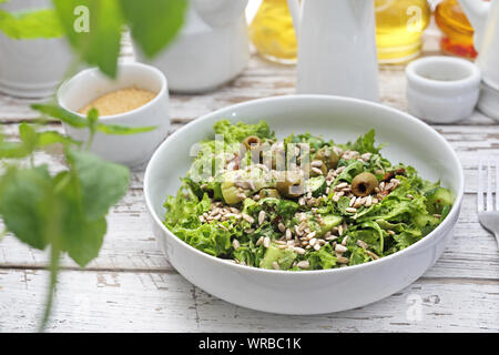 Salade verte aux olives, tomates séchées, les graines de tournesol servi avec une sauce à base d'herbes et d'huile. Banque D'Images