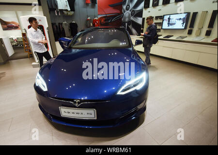 ****Fichier Personnes voir une voiture électrique Tesla Model S Tesla dans un magasin dans la ville de Hangzhou, Zhejiang Province de Chine orientale le 4 avril 2018. Électrique nous c Banque D'Images