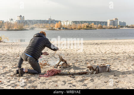 Pique-nique avec joie sur la plage avec un chien. Week-end sur la rivière bay. Banque D'Images