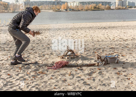 Pique-nique avec joie sur la plage avec un chien. Week-end sur la rivière bay. Banque D'Images