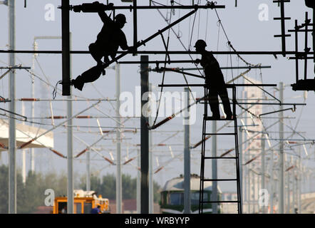 Les travailleurs migrants chinois appareils électrifiés montage sur le site de construction de la Huai'an East Railway Station de chemins de fer à grande vitesse dans la ville de Huai'an Banque D'Images
