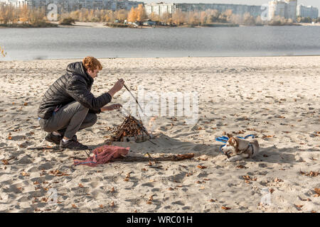 Pique-nique avec joie sur la plage avec un chien. Week-end sur la rivière bay. Banque D'Images