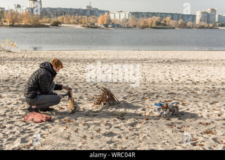 Pique-nique avec joie sur la plage avec un chien. Week-end sur la rivière bay. Banque D'Images