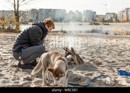 Pique-nique avec joie sur la plage avec un chien. Week-end sur la rivière bay. Banque D'Images