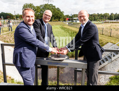 10 septembre 2019, Hambourg : Jens Kerstan (Bündnis90/Die Grünen, l-r), le sénateur de l'environnement de Hambourg, l'Olaf Müller, Directeur de la protection de l'eau dans l'entreprise d'état des routes, des ponts et des eaux (LSBG), et Michael Westhagemann (non partie), le sénateur pour le transport et l'économie, ouvrir la porte d'une usine de traitement biologique des eaux usées pour la route pour la mise en service. Il est destiné à de l'eau de pluie à partir d'un rayon de 40 hectares jusqu'à neuf tonnes de polluants par an, qui se composent principalement de microplastics de l'abrasion des pneus de voiture. Photo : Markus Scholz/dpa Banque D'Images