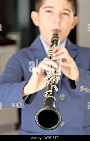 Garçon jouant de la clarinette. L'accent volontairement à la fin de la clarinette Banque D'Images