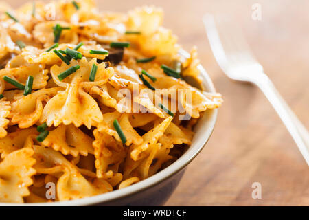 Bol de pâtes farfalle cuites de sangle ou les pâtes en sauce pesto frais de ciboulette, Close up Banque D'Images