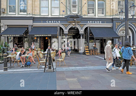 Les femmes en marche en dehors de la rue St Mary Castle Arcade & des gens assis à des tables à l'extérieur de Barker Rum & Fizz le centre-ville de Cardiff au Pays de Galles UK KATHY DEWITT Banque D'Images