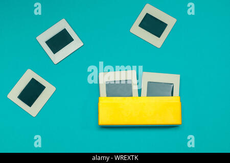 Retro Photo Collection de diapositives 35 mm, dans la ville animée de boîte jaune sur fond bleu turquoise Banque D'Images