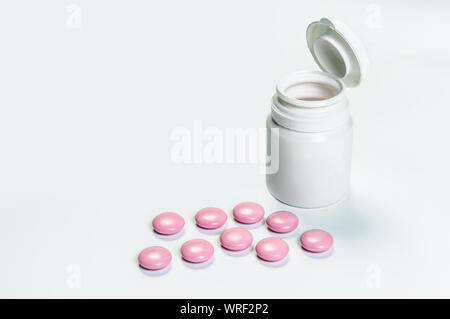 Close up de comprimés et médicaux bouteille sur fond blanc Banque D'Images