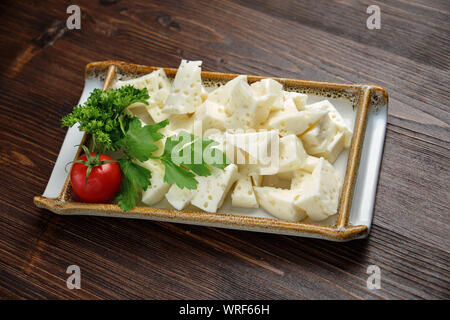 Belle table assiette de fromage sur une plaque blanche sur un fond sombre. Style alimentaire. Restaurant menu Banque D'Images