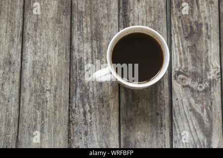 Tasse de café blanc sur l'ancien, table en bois. High angle view. Banque D'Images