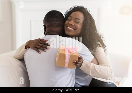 Embrassant tendrement aimée épouse mari, remerciant pour présenter romantique Banque D'Images