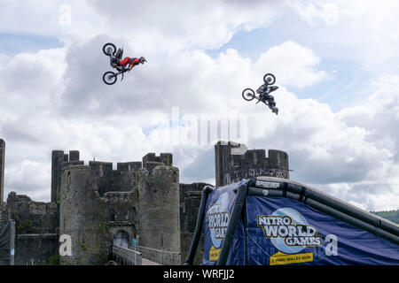 Caerphilly, Wales, UK. 10 septembre 2019. Trois Croix Moteur Freestyle (FMX) étoile effectuer le jamais vu avant "double backflip synchronisés train" devant tout aussi spectaculaire château de Caerphilly. Cascadeurs Jackson Strong, Josh Sheehan et Luc Ackerman, sont parmi les plus réussies FMX étoiles dans le monde. L'affichage fait la promotion de la prochaine 2020 Monde Nitro Jeux à être mis en scène dans la Principauté Stadium de Cardiff. Crédit : Mr Standfast/Alamy Live News o Banque D'Images