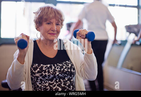 Portrait of a senior woman lifting-haltères dans une salle de sport. Banque D'Images