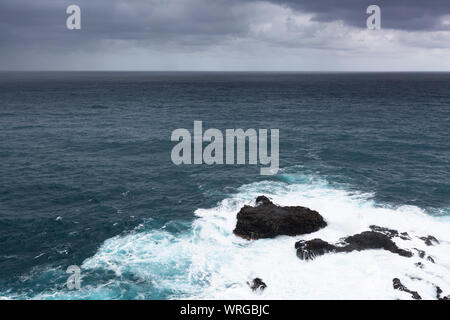 Tempête et la pluie avec de grandes vagues qui viennent se briser sur les récifs de Playa de Nogales à La Palma, Espagne. Banque D'Images