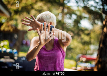 Mid adult woman lui couvre le visage. Banque D'Images