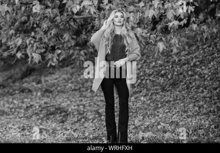 Tenues décontractées confortable pour la fin de l'automne. Tenue confortable. Adorable petite fille blonde posing in outfit chaleureux et cosy de l'automne nature fond flou. Création pour agréable fin de semaine. Femme à pied. La lumière au coucher du soleil Banque D'Images