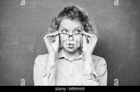 Nouvelle année scolaire. Jeune fille à se préparer à l'examen. surpris en étudiant à lunettes tableau. retour à l'école. tableau noir. Informelle et formelle l'éducation non formelle. girl enseignant à l'école leçon. quelle surprise. Banque D'Images