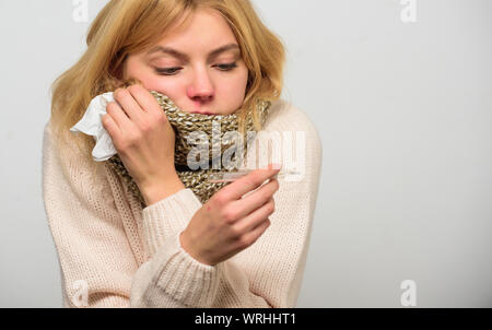 Fille en tissu écharpe tenir thermomètre et close up. Mesurer la température. Concept à haute température. La fièvre de la pause des recours. La prise de température et d'évaluer les symptômes. Femme se sent gravement malade l'éternuement. Banque D'Images