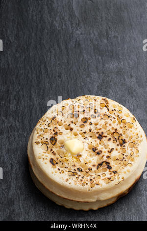 Pile de crumpets complet isolé sur la table Banque D'Images