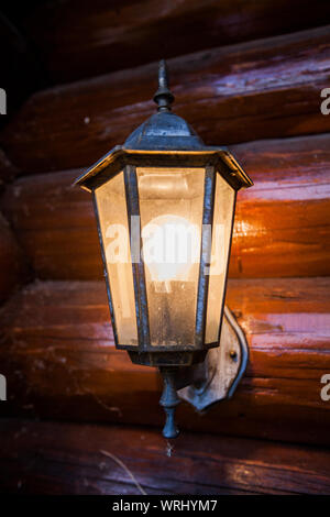 Les feux de la lampe à l'ancienne maison de bois, sur l'extérieur. Banque D'Images