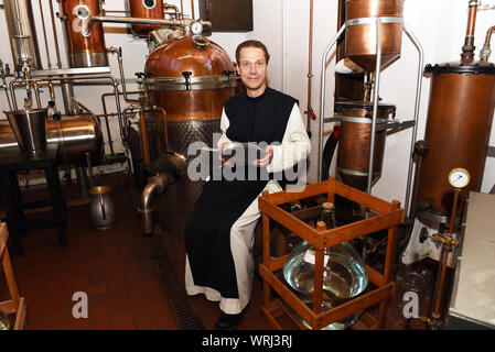 15 juillet 2019, Bochum, Rhénanie du Nord-Westphalie : Père Justinus se trouve dans la distillerie, est titulaire d'une pelle de mesure avec les baies de genièvre dans ses mains et regarde dans la caméra du photographe, produit sa propre preuve de gin et l'appelle "onatic Dry Gin'. Les herbes qu'il a besoin sont plantées et récoltées dans le jardin du monastère. Il obtient le genévrier de Toscane et le grain d'où l'alcool est obtenu qu'il obtient de l'abbaye de Heiligenkreuz mère dans la forêt viennoise. Dans le monastère lui-même il n'est pas autorisé à brûler de gin, parce qu'il n'a pas de droits de distillation. Pour ce qu'il conduit à Banque D'Images