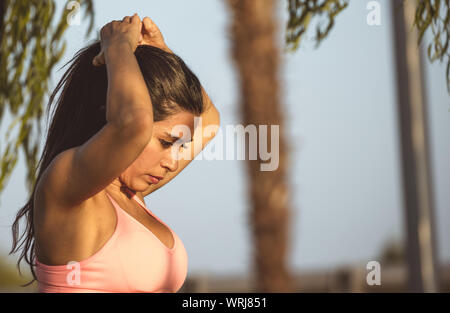 Femme latine et brunette se termine l'exercice, portant haut rose et noir leguins. Banque D'Images