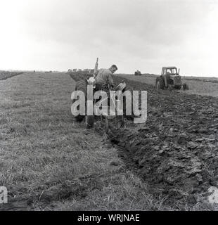 Années 1960, historique, un agriculteur sur son tracteur laboure un champ dans un concours de labour, Crediton, England, UK. Les points sont attribués pour la linéarité et la propreté des sillons. Banque D'Images