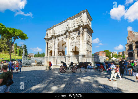 Une calèche et attendre du pilote par l'Arc de Constantin près du Forum en tant que touristes passent par le célèbre hôtel de luxe à Rome, Italie Banque D'Images