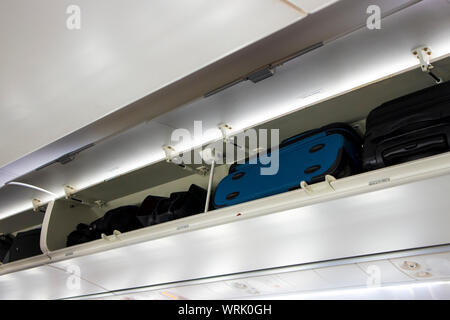 Exploitation d'assurance bagages dans l'avion de passagers penderie étagères, portes ouvertes. Concept de sécurité dans l'avion. Banque D'Images