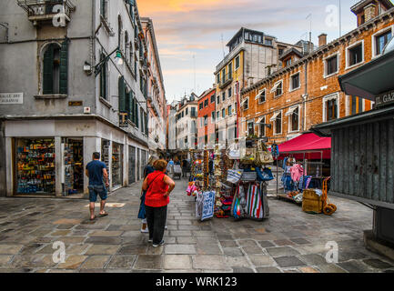 Boutique de souvenirs pour touristes et les sacs à main en face d'un marché comme ils visiter sur un matin tôt dans le centre historique de Venise, Italie. Banque D'Images
