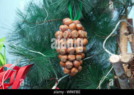 Décoration de Noël sous la forme d'une noisette, dans le fond bleu, branches d'arbres de Noël. Beaux ornements de Noël. Banque D'Images