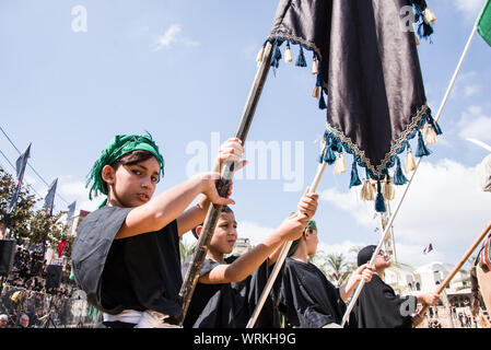 Les gens de Jibchit, municipalité de Nabatiyeh, Liban, pleuré la mort de l'Imam Hussein, petit-fils du Prophète Mohamed, à travers une reconstitution de sa mort pendant la bataille de Karbala en 680 AD. Une distribution de 100 personnes y ont pris part, avec des chevaux et un chameau. Liban, 10 Septembre 2019 Banque D'Images