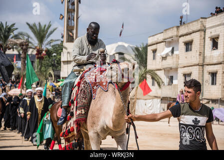 Les gens de Jibchit, municipalité de Nabatiyeh, Liban, pleuré la mort de l'Imam Hussein, petit-fils du Prophète Mohamed, à travers une reconstitution de sa mort pendant la bataille de Karbala en 680 AD. Une distribution de 100 personnes y ont pris part, avec des chevaux et un chameau. Liban, 10 Septembre 2019 Banque D'Images