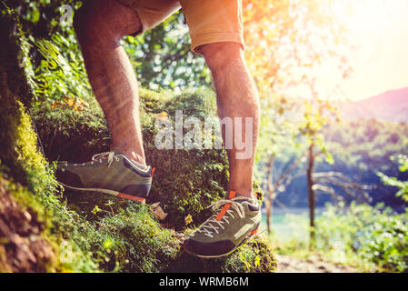 Les randonneurs de grimper sur un des rochers couverts de mousse Banque D'Images