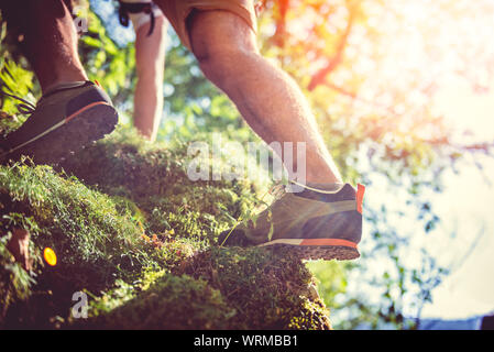 Les randonneurs de grimper sur un des rochers couverts de mousse Banque D'Images