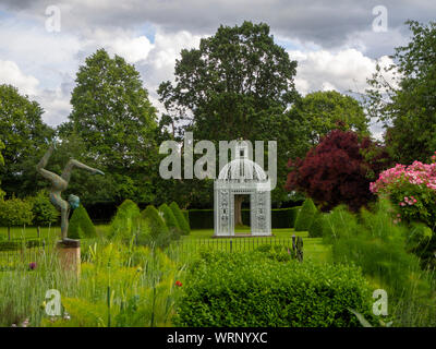 Chenies Jardin du Manoir à la recherche vers le parterre et blanc en juin avec la pagode birdcage et topiaire sculpture acrobatique. Banque D'Images