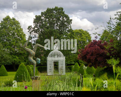 Chenies Jardin du Manoir à la recherche vers le parterre et blanc en juin avec la pagode birdcage et topiaire sculpture acrobatique. Banque D'Images