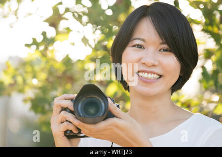 Portrait Young Asian woman with camera Banque D'Images